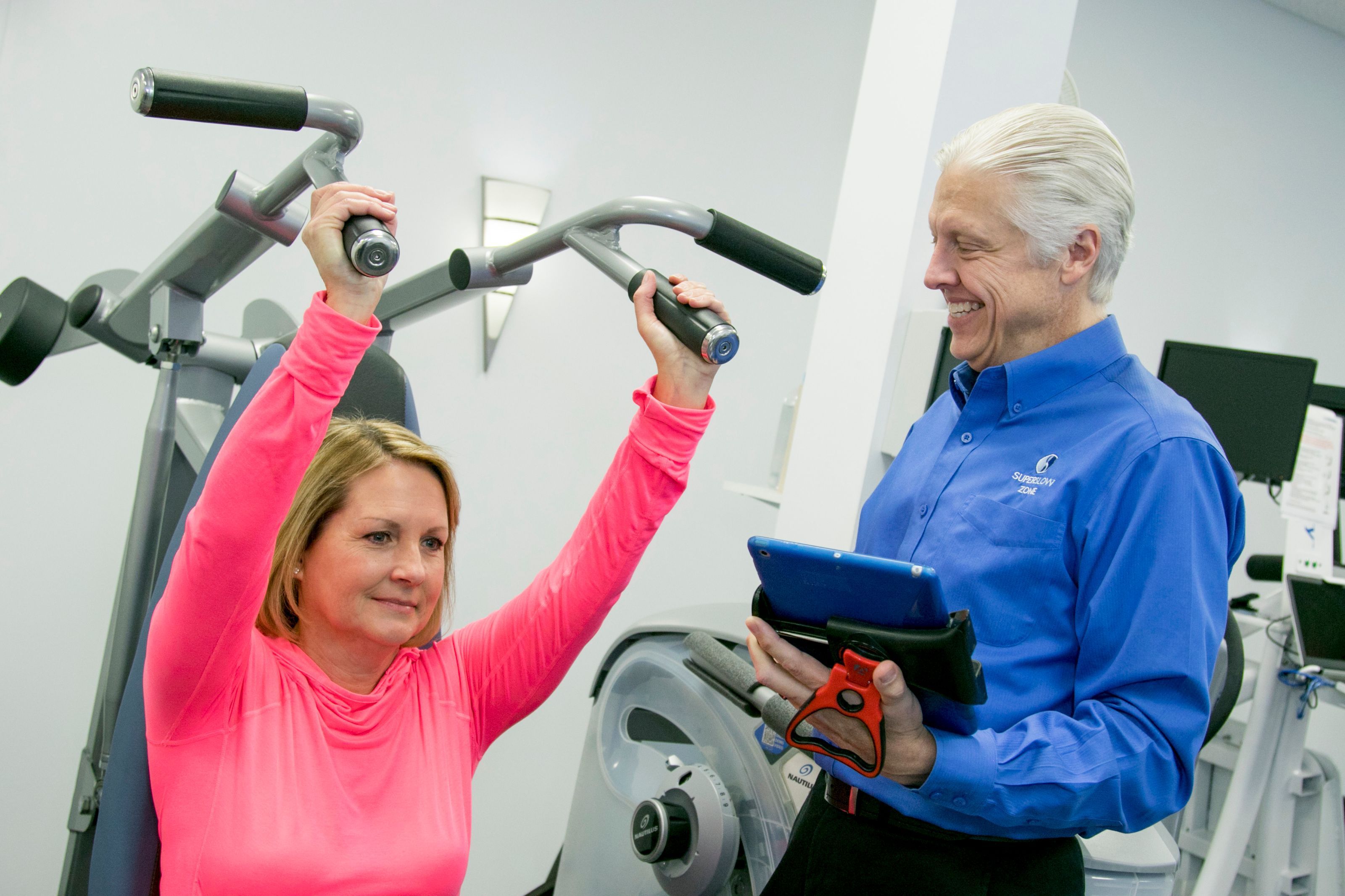 A woman doing supervised strength training with a certified SuperSlow Zone instructor